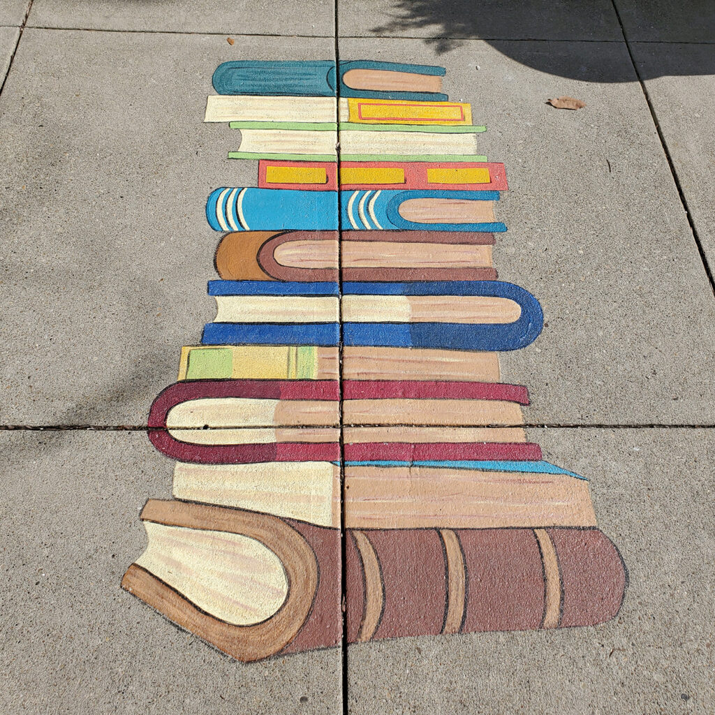 A painting of a stack of books on the sidewalk. 
