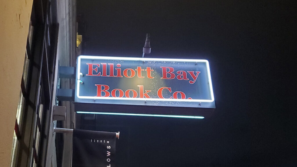 A sign for Elliott Bay Book Co. at night. 