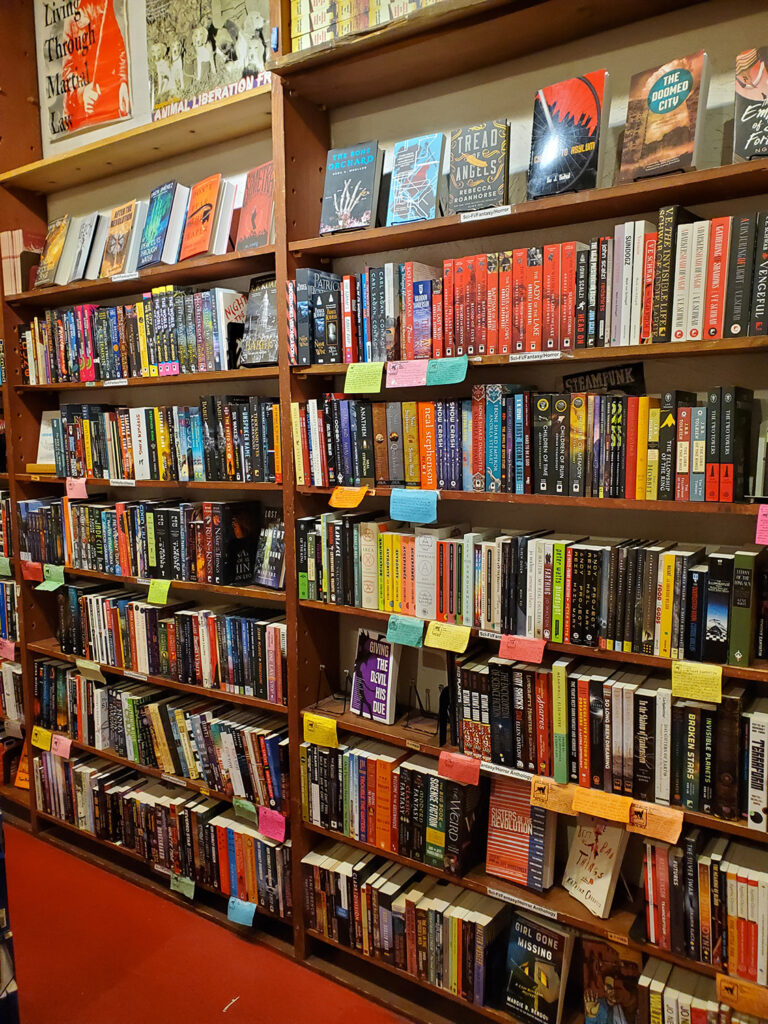 The sci-fi and fantasy section of Left Bank Books. There are lots of colorful staff picks shelf talkers.